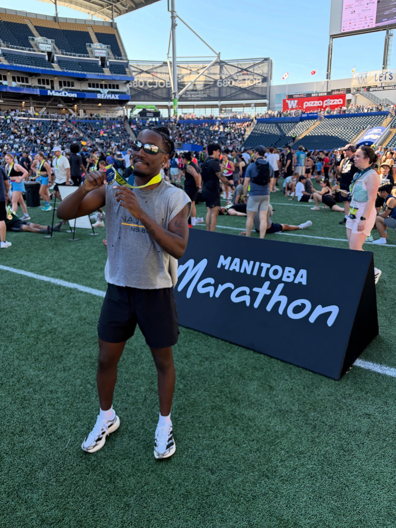 Kudada holding his Manitoba Marathon medal at the stadium